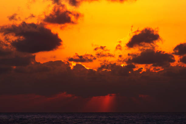 The Pacific Ocean and the sun setting behind the clouds as seen from a cruise ship