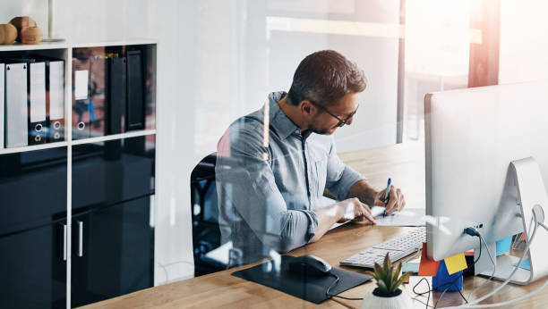 istock Business man, writing and planning in office for accounting report, documents or paperwork. Professional, mature worker or accountant sign proposal, review or print agreement of summary or conclusion 2160190414
