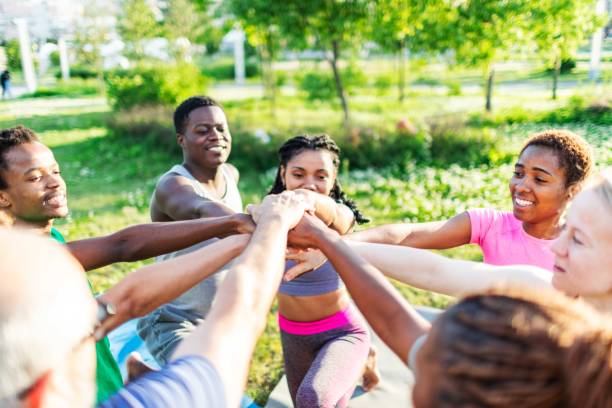 Multiracial group of people of friends standing and stacking their hands together