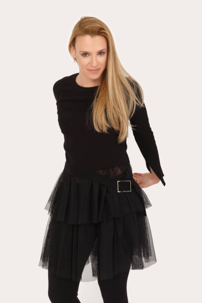 istock Blonde lady stretching hands behind back on light gray background 2160194616