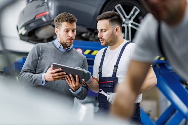 istock Male customer and auto mechanic using touchpad in a workshop. 2160196469