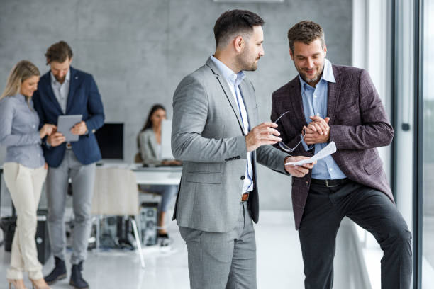 istock Smiling businessmen working on reports in the office. 2160196590