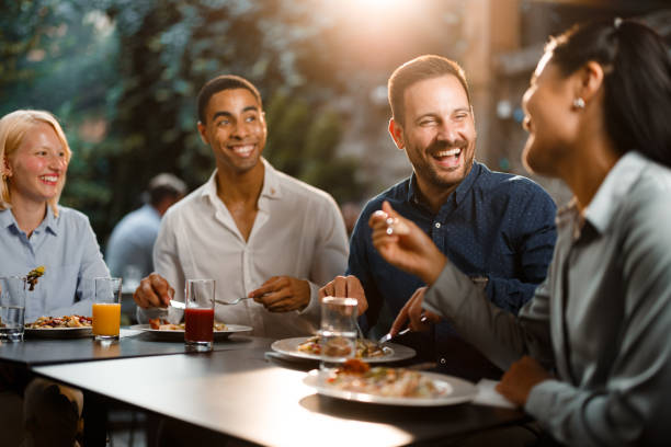 istock Happy colleagues talking while enjoying in lunch at a restaurant. 2160197099