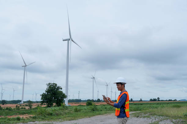 istock asian engineer using digital tablet. working at wind turbine farm. 2160198561