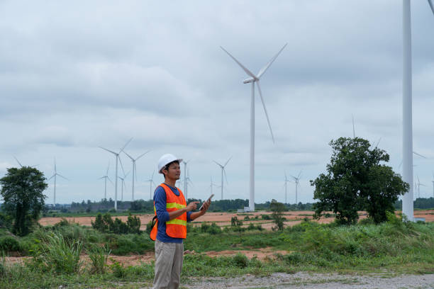 istock asian engineer using digital tablet. working at wind turbine farm. 2160198562