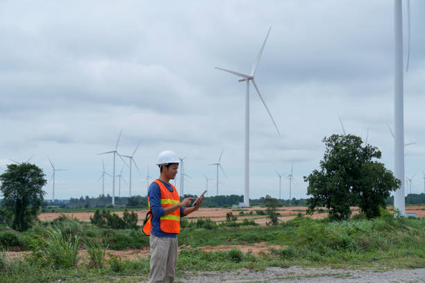 istock asian engineer using digital tablet. working at wind turbine farm. 2160198586
