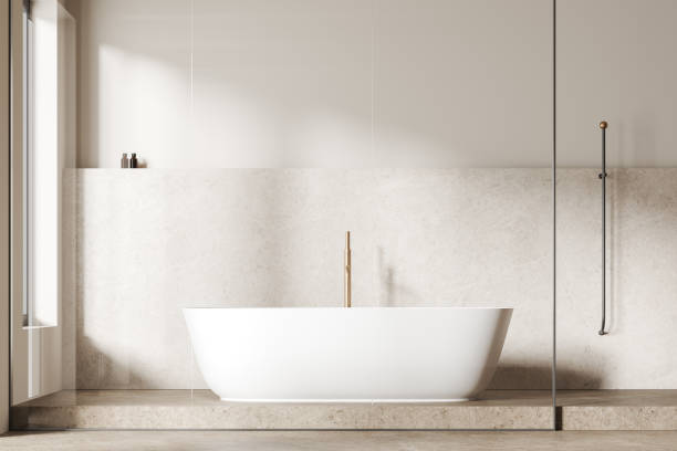 istock Modern bathroom with a freestanding white bathtub, light beige tiled wall, and minimalistic decor, light background, concept of contemporary and minimalist design.  3D Rendering 2160199613