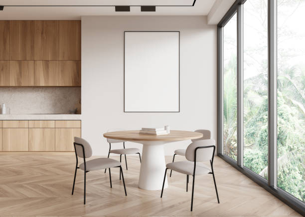 istock A modern dining room with a blank poster on the wall and large windows showing greenery. Light colors and minimalist design create a calm atmosphere. Poster mockup concept.  3D Rendering 2160201041