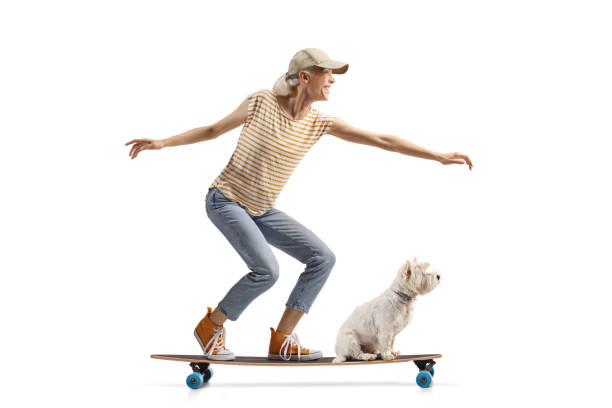 istock Cheerful young riding a longboard with a dog 2160201060
