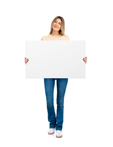 istock Young woman standing with blank mock up banner, white background 2160201475