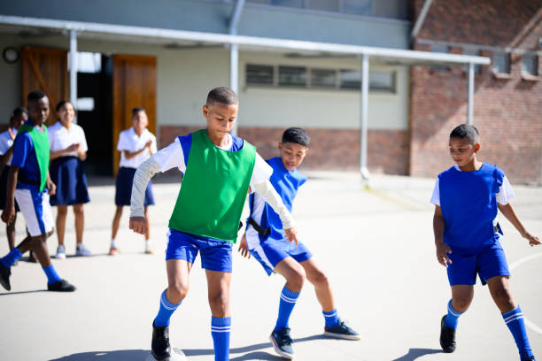 istock School boy dribbling past defenders in school yard  soccer practise 2160203089