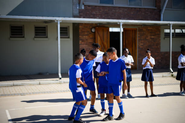 istock Young black team mates huddle and laugh during school soccer practise 2160203161