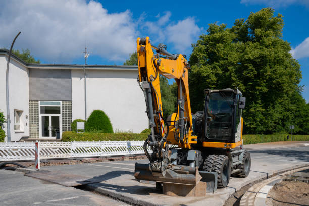 istock A yellow excavator pauses by a building in a sunny, summer day 2160203548