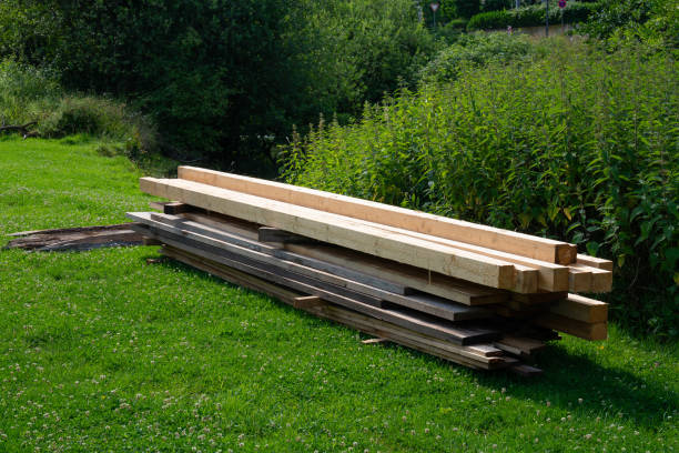 istock A stack of wooden beams resting in a lush green meadow 2160203591