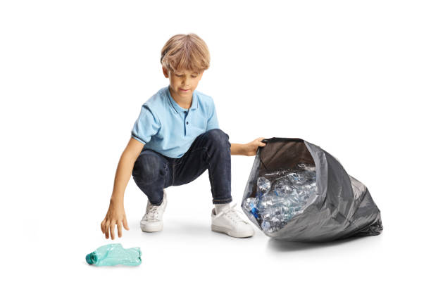 istock Boy kneeling and collecting plastic bottles 2160203638