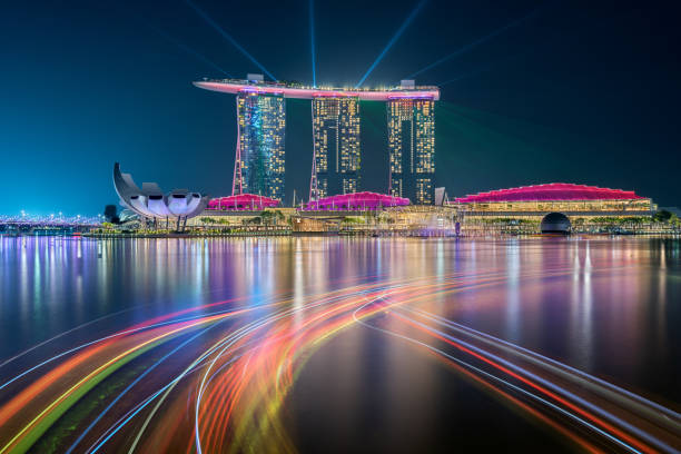 Singapore - October 24, 2019: Singapore skyline taken at night with the famous hotel Marina Bay Sands, the reflections of the buildings and the light trails of the boats painted in the bay water