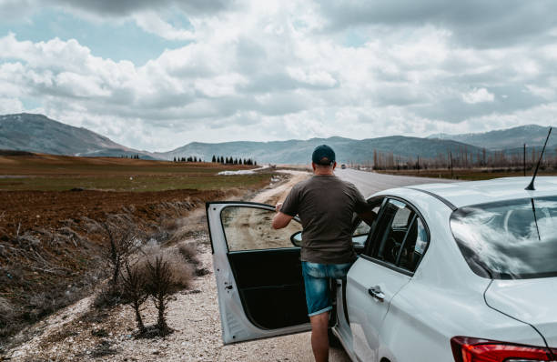 istock Man in a car looking forward. Travelling by car in mountains 2160204736