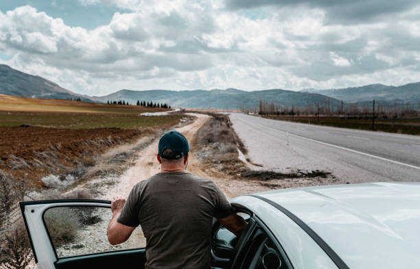 istock Man in a car looking forward. Travelling by car in mountains 2160204767