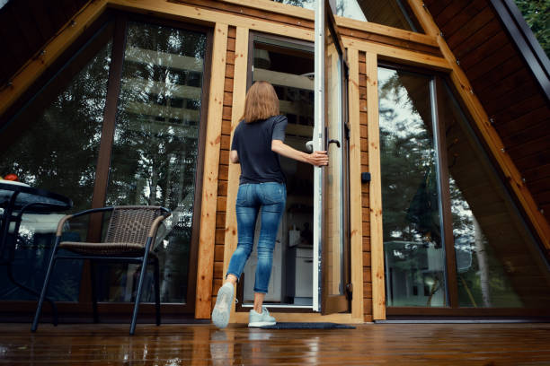 istock Woman enters forest cabin, back view 2160205182