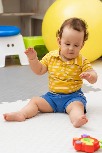 istock Young boy sits on the floor during a physical therapy session. Bobath therapy 2160207316