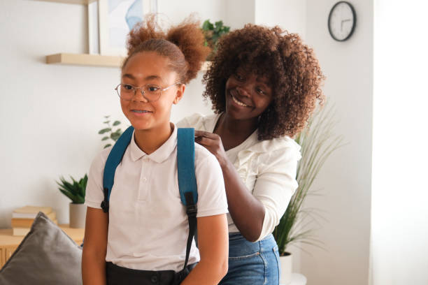 istock Loving mother helping daughter getting ready for school 2160207911