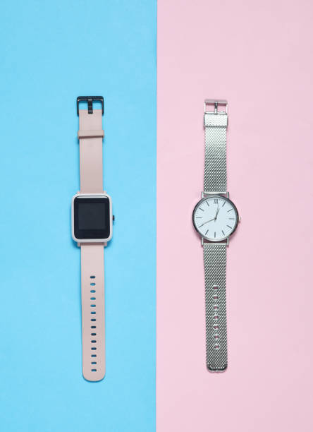 istock Modern smart and analog watches on a blue-pink background. Top view 2160208339