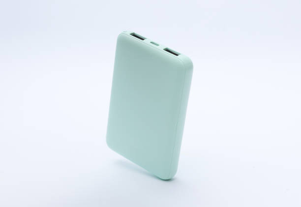 Mint green plastic power bank floating on white background