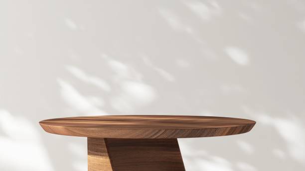 istock Modern, minimal round wooden pedestal table podium in dapple sunlight, shadow on white wall 2160213659