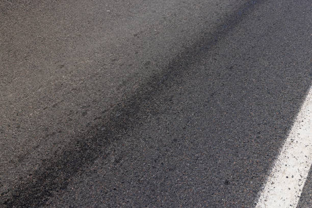 istock white road markings on asphalt, close up 2160213995