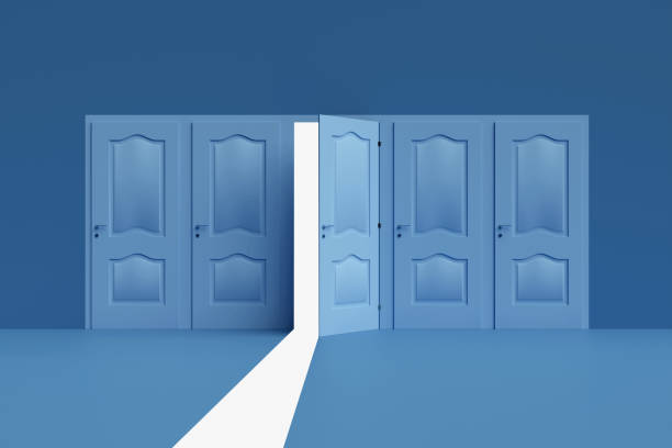 istock Open door revealing light in dark room representing opportunity 2160216973
