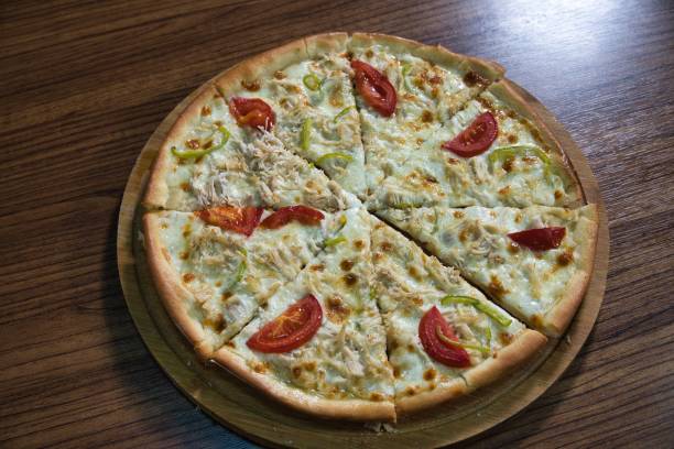 istock Sliced Chicken and Tomato Pizza on Wooden Board 2160217637