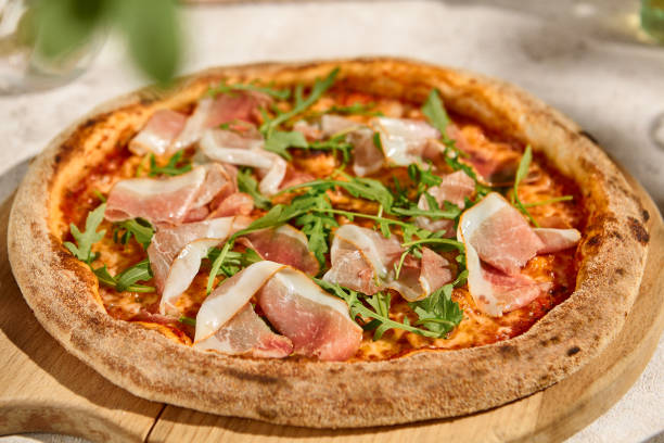 istock Delicious Prosciutto and Arugula Pizza in Sunlit Summer Setting 2160218389