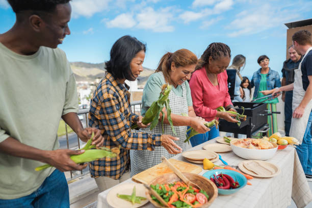 istock Multigenerational people doing barbecue at home's rooftop - Multiracial friends having fun eating and cooking together during weekend day - Summer and food concept - Main focus on latin woman face 2160219274