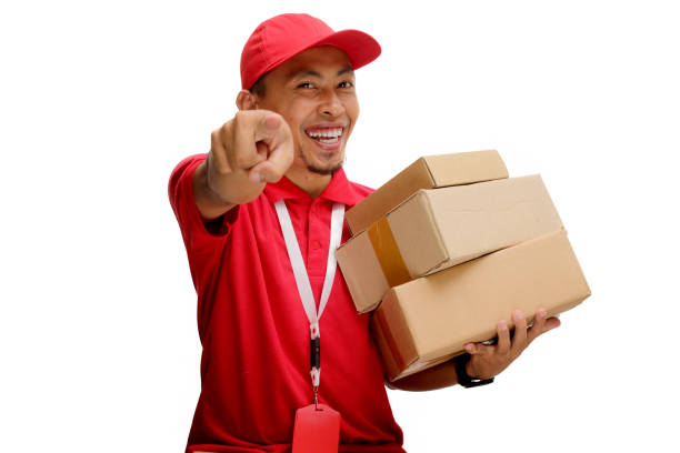 istock Asian Delivery Man Pointing at Camera with Cardboard Box 2160222996