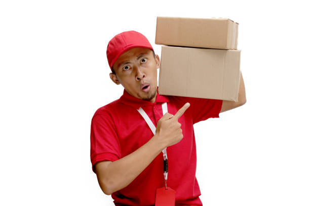 istock Asian Delivery Man Pointing at Cardboard Box Packages 2160223020