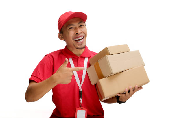 istock Asian Delivery Man Pointing at Cardboard Box Packages 2160223168