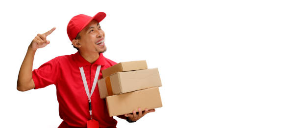 istock Asian Delivery Man Pointing with Cardboard Box 2160223351