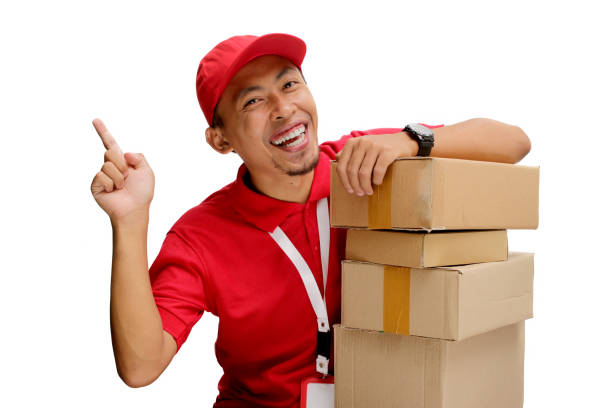 istock Asian Delivery Man Pointing with Cardboard Box 2160224059