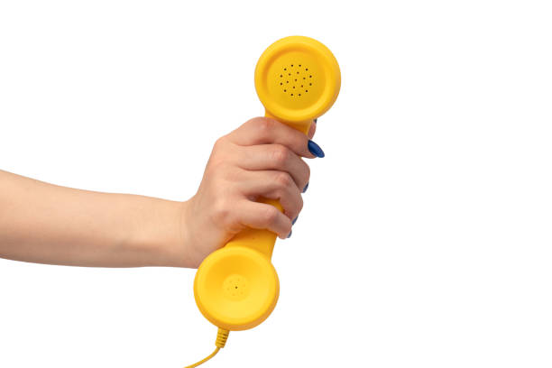 istock Yellow handset in woman hand isolated on white. Copy space. 2160224463