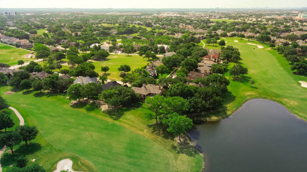 istock Upscale golf community in master planned subdivision urban sprawl, grassy fairway, sand trap bunkers, golfer playing with expensive new development two story mansion houses, Plano Texas, aerial 2160225099