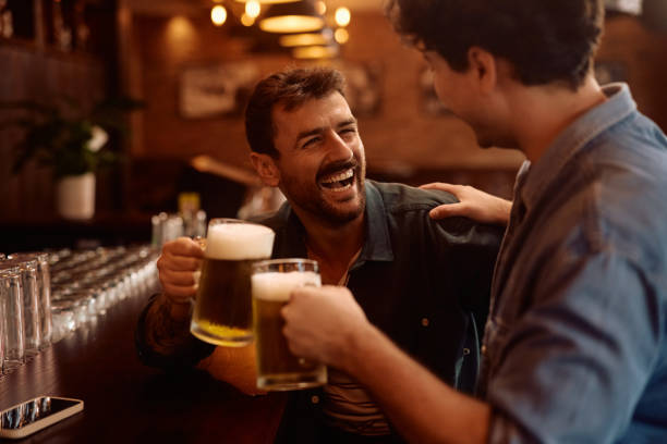 istock Cheerful male friends toasting with beer in a bar. 2160226502