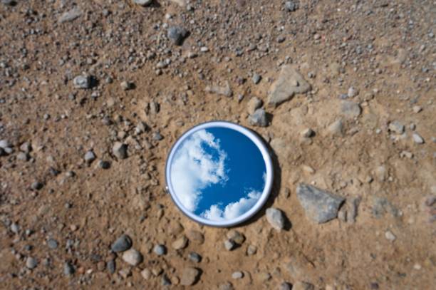 istock Blue sky reflected in the mirror breaking up on dry soils. Climate change concept. 2160227705