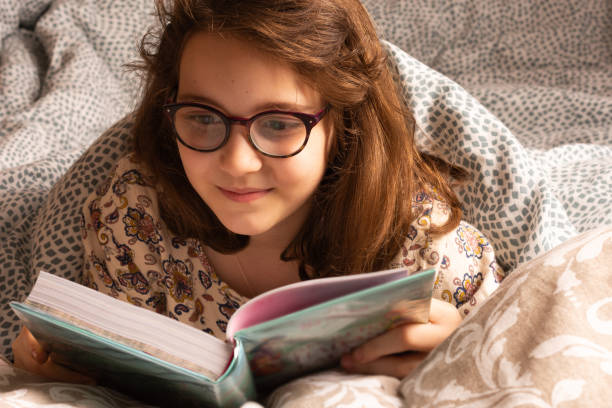 istock young and beautiful girl reading in bed 2160228750