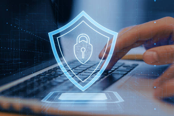 istock An illustration of a digital security shield overlaying a laptop with a user's hand, on a dark blue, technology-themed background, symbolizing cyber protection 2160229424