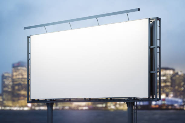 istock Blank white billboard on cityscape background at evening, perspective view. Mock up, advertising concept 2160232420