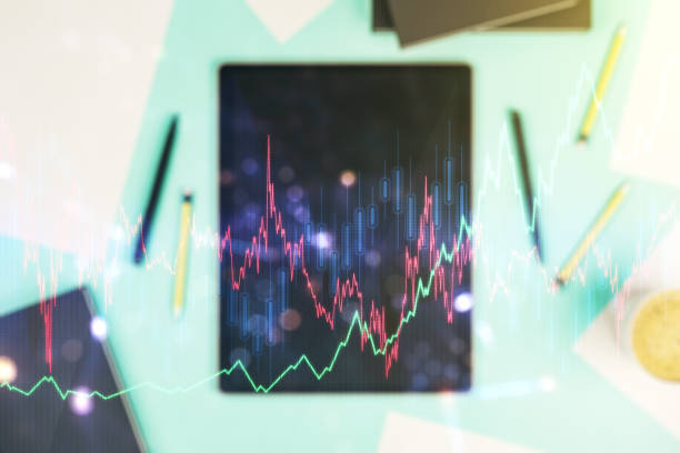Abstract creative financial graph and modern digital tablet on background, top view, forex and investment concept. Multiexposure