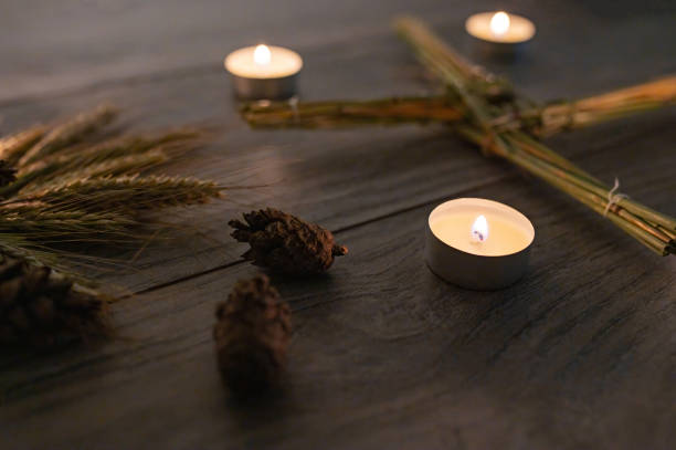 Wiccan altar for Imbolc sabbath. winter-spring pagan festive ritual. Brigid's cross, candle, wheel of the year on wooden table. symbol of Imbolc holiday, spring equinox. top view