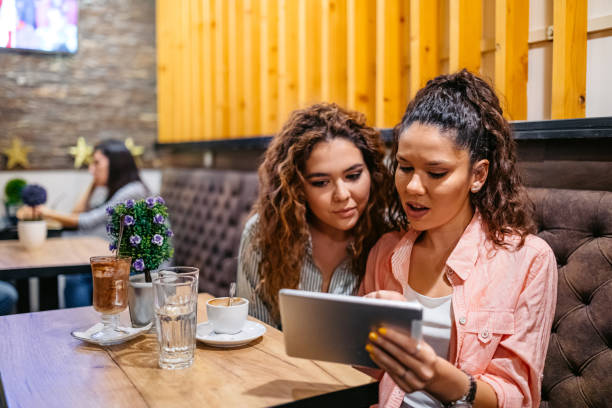 istock Two Female Friends Being Surprised By Something On The Digital Tablet While Drinking Coffee In A Café 2160238595