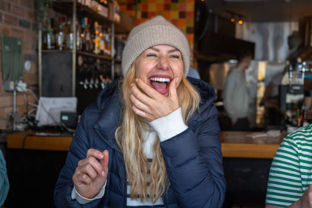 Beautiful young woman smiling in winter clothes. Wearing hat, scarf and gloves.