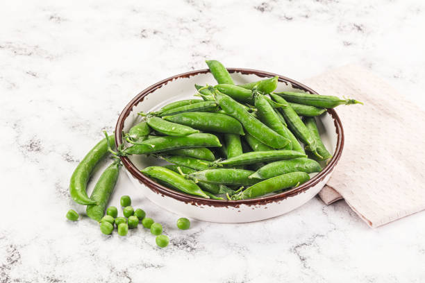 istock Sweet young green peas heap 2160239294